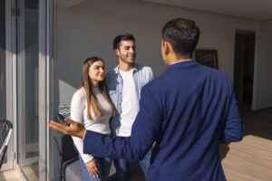Agent immobilier faisant visiter un appartement à un couple d’acheteurs à la rentrée.