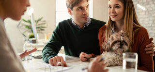 Couple en rendez-vous bancaire pour obtenir un crédit immobilier à la rentrée 2025.