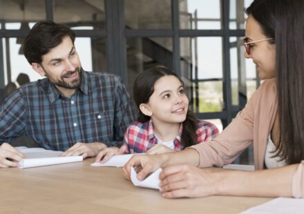 Famille préparant la rentrée scolaire tout en signant un contrat d’achat immobilier.