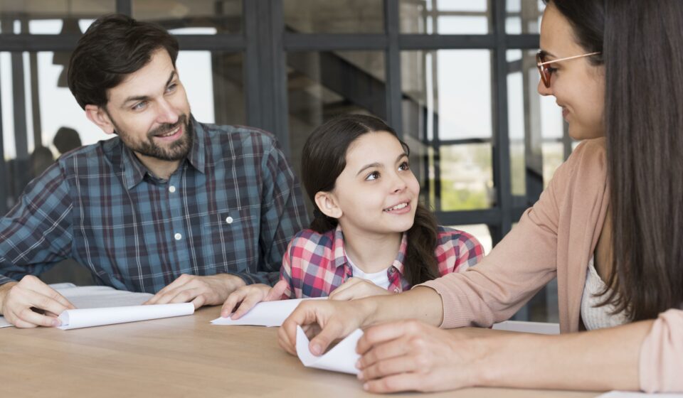 Famille préparant la rentrée scolaire tout en signant un contrat d’achat immobilier.