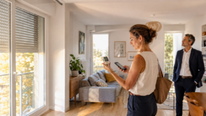 Acquéreuse mesurant la température intérieure d’un appartement pendant une visite immobilière