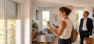 Acquéreuse mesurant la température intérieure d’un appartement pendant une visite immobilière