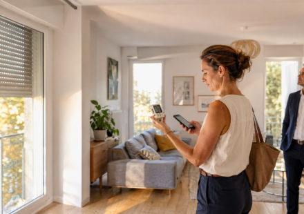 Acquéreuse mesurant la température intérieure d’un appartement pendant une visite immobilière