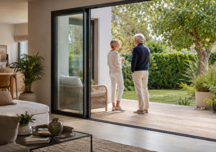 Immobilier et les rez-de-chaussée : retrouvent-ils de la valeur avec le vieillissement de la population ? Couple de seniors dans un appartement accessible en rez-de-chaussée ouvert sur un jardin