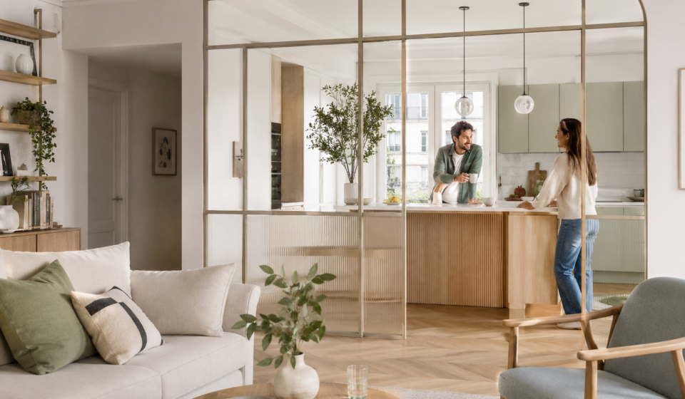 Verrière intérieure : toujours tendance ou déjà dépassée en 2026 ? Couple dans un séjour lumineux séparé de la cuisine par une verrière intérieure