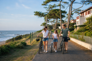 Une famille se promène à vélo près de l’océan et des quartiers résidentiels d’Anglet